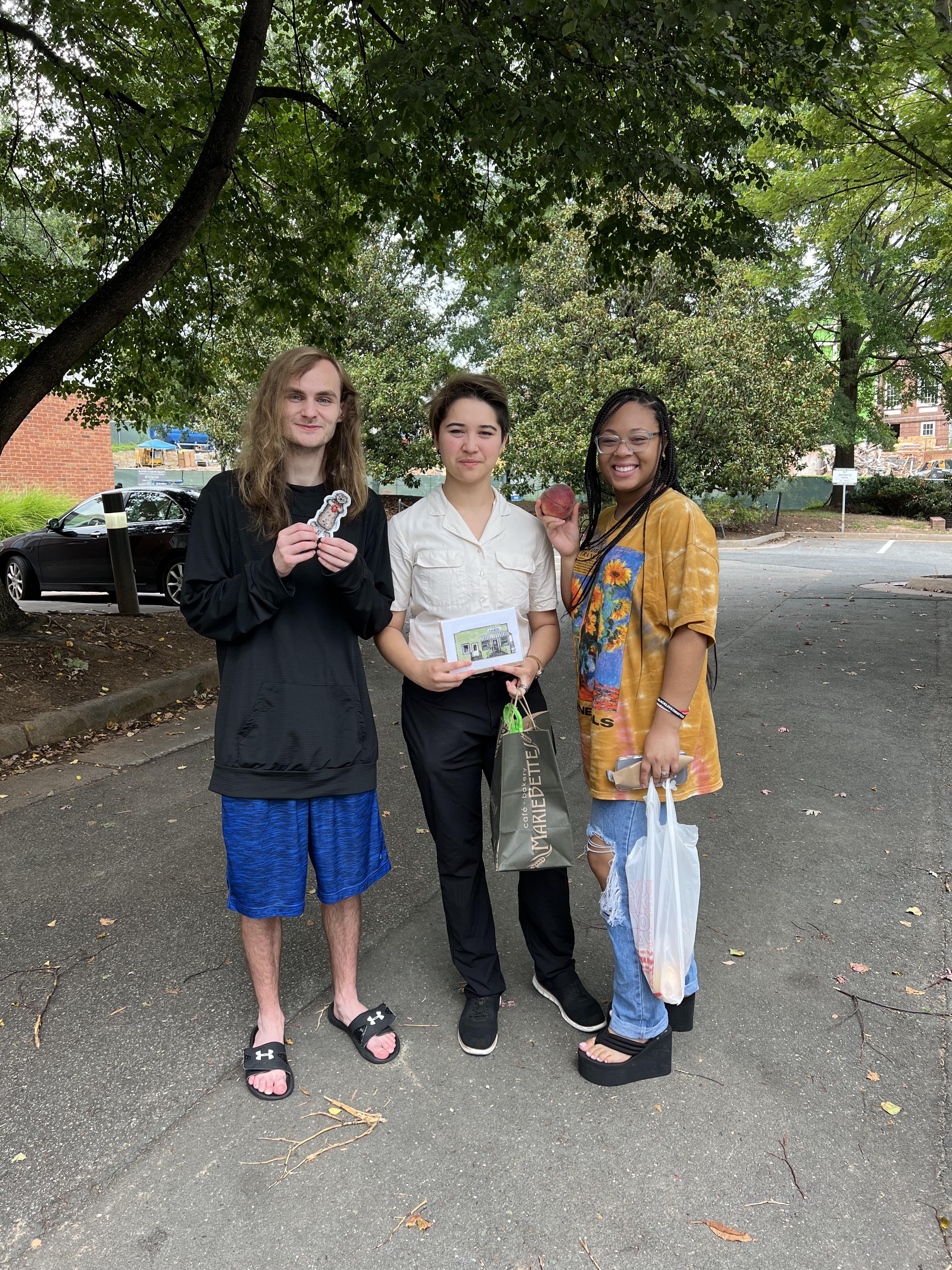 Members of the ASL pod holding their purchases from the farmer's market.